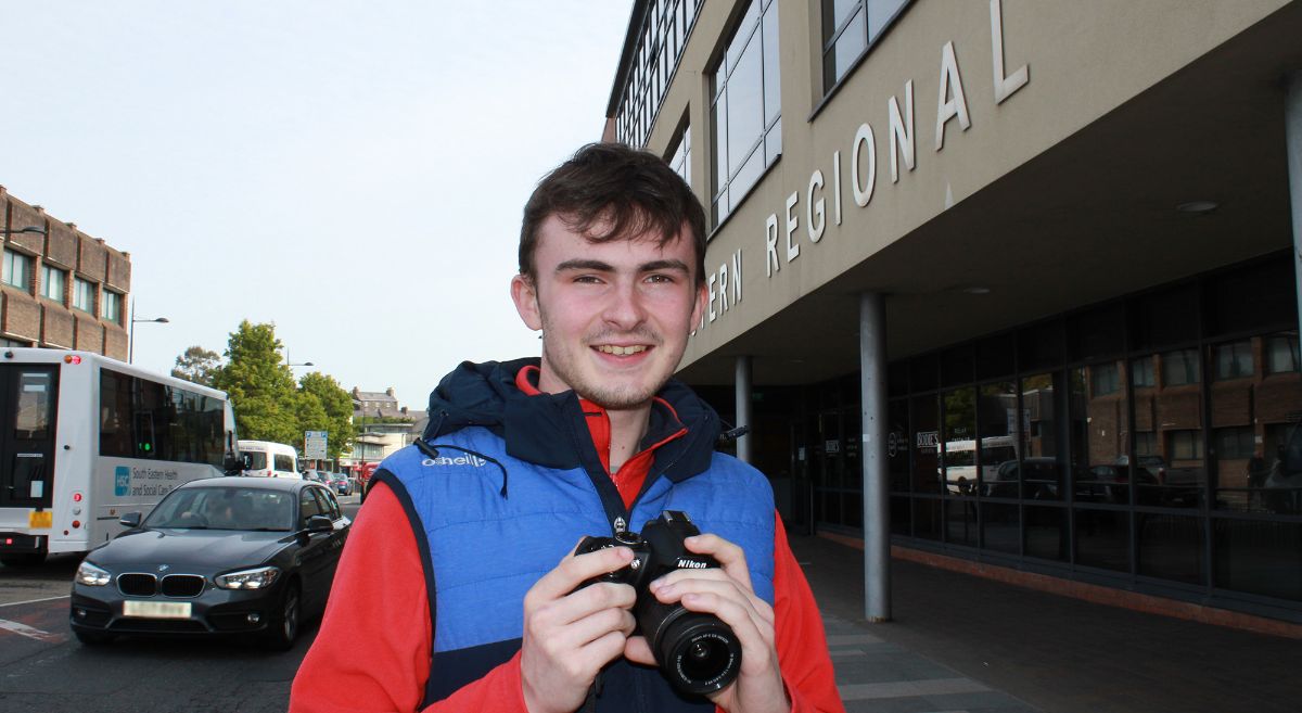 Aaron Rice pictured outside SERC Downpatrick Campus with his camera on the main street